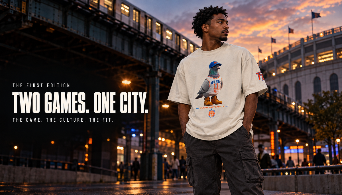 Adult male model wearing the faded-bone Flavor First Sports Borough Bird No. 11 oversized tee beneath an elevated train near a Bronx stadium district at dusk.